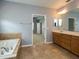 Bathroom with a long vanity, bathtub, and neutral tile flooring at 2072 Hartz Aly, Orlando, FL 32814
