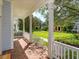 Covered porch with white railings and brick flooring, offering a view of the landscaped community lawn at 2072 Hartz Aly, Orlando, FL 32814
