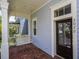 Inviting front porch with a swing and a decorative glass front door entrance at 2072 Hartz Aly, Orlando, FL 32814