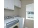 Bright laundry room features a washer and dryer, white cabinets, and a window at 2072 Hartz Aly, Orlando, FL 32814