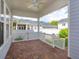 Covered porch with brick flooring and white railing provides a cozy outdoor space at 2072 Hartz Aly, Orlando, FL 32814