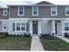 Two-story townhome with gray siding, landscaping, and walkway at 6138 Galloping Dr, Apopka, FL 32712