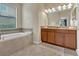 Charming bathroom with soaking tub, dual sinks, tile accents, and ample counter space for a spa-like experience at 8930 Azalea Sands Ln, Davenport, FL 33896