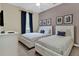 Bedroom featuring two beds, matching grey bedding, and artwork creating a calming and coordinated space at 8930 Azalea Sands Ln, Davenport, FL 33896