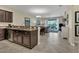 Open-concept kitchen with dark cabinetry, granite counters, stainless dishwasher, and seamless flow to living area at 8930 Azalea Sands Ln, Davenport, FL 33896