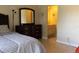 Cozy bedroom featuring dark wood furniture, a queen-sized bed, and an ensuite bathroom at 3276 Candle Ridge Ct # 202, Orlando, FL 32822