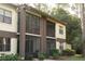 Exterior elevation of the condo building features a screened-in lanai, and well-maintained landscaping at 3276 Candle Ridge Ct # 202, Orlando, FL 32822