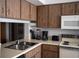 Well-equipped kitchen showcasing wood cabinetry, ample counter space, and modern appliances for all cooking needs at 3276 Candle Ridge Ct # 202, Orlando, FL 32822