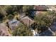 Aerial view of home featuring a pool, screened enclosure, solar panels, and mature trees at 17512 Woodcrest Way, Clermont, FL 34714