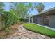 Backyard with a stone path, landscaping, and a screened-in patio at 2657 Queen Mary Pl, Maitland, FL 32751