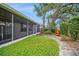 Backyard with a screened-in patio and a lush lawn with stone landscaping and a fire pit at 2657 Queen Mary Pl, Maitland, FL 32751