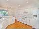 Bright kitchen featuring white appliances, white cabinetry, and hardwood floors at 2657 Queen Mary Pl, Maitland, FL 32751
