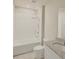 A full white bathroom with tiled walls, a bath/shower combo and granite topped vanity at 291 Whistling Duck Trl, St Cloud, FL 34771