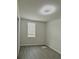 A bright bedroom with a window, wood-look floors and a modern lighting fixture overhead at 291 Whistling Duck Trl, St Cloud, FL 34771