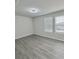 Bedroom with wood-look floors and natural light from large window at 291 Whistling Duck Trl, St Cloud, FL 34771