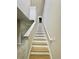 Stairway with wood-look steps and white risers, leading to the upper level at 291 Whistling Duck Trl, St Cloud, FL 34771