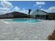 Community pool with clubhouse and sun bathing lounge area surrounded by lush landscaping at 7358 Sw 76Th Ter, Ocala, FL 34481