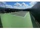 Community tennis court surrounded by fence and lush greenery, perfect for sports enthusiasts at 7358 Sw 76Th Ter, Ocala, FL 34481
