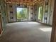 Interior space under construction with newly framed walls and large window, offering potential for a bright living space at 405 Long And Winding Rd, Howey In The Hills, FL 34737