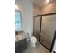 Modern bathroom featuring gray vanity and sleek walk-in shower with black trim at 2110 Whitney Marsh Aly, Orlando, FL 32804