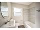 Bright bathroom features a stylish vanity, toilet, and a tub with elegant gray tiled walls at 507 Francis Blvd, Lakeland, FL 33801