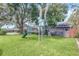Well-maintained backyard with mature trees, swing set and a lush green lawn at 51 Oakleigh Ln, Maitland, FL 32751