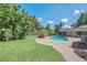 Aerial view of the backyard pool and patio area, surrounded by a well-manicured lawn and lush tropical foliage at 51 Oakleigh Ln, Maitland, FL 32751