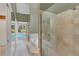Light filled bathroom with a clear glass shower and a soaking tub overlooking a window to an outdoor pool at 51 Oakleigh Ln, Maitland, FL 32751