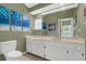 Bright bathroom featuring a white vanity with ample storage space, tiled floors, and stylish aquatic themed artwork at 51 Oakleigh Ln, Maitland, FL 32751