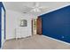 Bedroom with a large blue accent wall, a white dresser, and beige carpeting at 51 Oakleigh Ln, Maitland, FL 32751