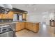 Stylish kitchen with stainless steel appliances, wood cabinets, stone countertops, and an island overlooking the living area at 51 Oakleigh Ln, Maitland, FL 32751