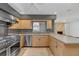 Bright kitchen featuring a stainless steel range, light wood cabinets, and breakfast bar seating with stone countertops at 51 Oakleigh Ln, Maitland, FL 32751