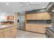 A kitchen with stainless steel appliances, stone countertops and an island overlooks the living room and dining room at 51 Oakleigh Ln, Maitland, FL 32751