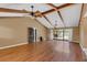 Spacious living room featuring vaulted ceilings with wooden beams, hardwood floors, and sliding glass doors to the backyard at 51 Oakleigh Ln, Maitland, FL 32751