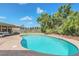 Inviting backyard pool area with brick pavers and lush tropical landscaping, creating a relaxing outdoor space at 51 Oakleigh Ln, Maitland, FL 32751