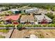 Wide aerial view of the property, displaying its proximity to nearby commercial buildings and greenery at 1021 Fantasy Dr, Davenport, FL 33896