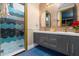 A luxurious bathroom features double vanities, designer mirrors, and a glass-enclosed shower with custom tiling at 1021 Fantasy Dr, Davenport, FL 33896