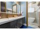 Bathroom features a double vanity with decorative mirrors and a walk-in shower for convenience and style at 1021 Fantasy Dr, Davenport, FL 33896