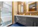 Beautiful bathroom featuring a double sink vanity, stunning mirrors, and a glass-enclosed shower at 1021 Fantasy Dr, Davenport, FL 33896