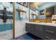 Bathroom features a double vanity, decorative mirror, and a glass-enclosed shower for a luxurious experience at 1021 Fantasy Dr, Davenport, FL 33896