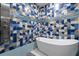 Modern bathroom featuring a soaking tub, a mosaic tile wall, and a rainfall shower head at 1021 Fantasy Dr, Davenport, FL 33896