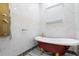 Clean bathroom features white walls, a red clawfoot tub with gold fixtures, and a modern shower at 1021 Fantasy Dr, Davenport, FL 33896