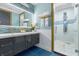 Bright bathroom with tiled mirror accent, double vanity, and glass enclosed shower at 1021 Fantasy Dr, Davenport, FL 33896