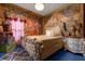 Themed bedroom features rock wall, queen bed, and wooden floors at 1021 Fantasy Dr, Davenport, FL 33896