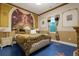 Cozy bedroom features custom wall murals, a queen bed, lamps, and large window at 1021 Fantasy Dr, Davenport, FL 33896
