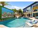Resort-style pool area with a rock slide, waterfalls, lush landscaping, and comfortable lounge chairs at 1021 Fantasy Dr, Davenport, FL 33896