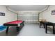 A versatile garage space featuring a pool table, foosball, and basketball hoop for entertainment at 503 Balmoral Dr, Davenport, FL 33896
