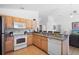 Well-equipped kitchen featuring wood cabinets, modern appliances, and a breakfast bar open to the living area at 503 Balmoral Dr, Davenport, FL 33896