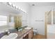 Bright main bathroom featuring double sinks, a large mirror, a soaking tub, and a separate shower at 503 Balmoral Dr, Davenport, FL 33896