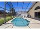 Sparkling in-ground pool featuring a screened-in enclosure and an adjacent patio area at 503 Balmoral Dr, Davenport, FL 33896